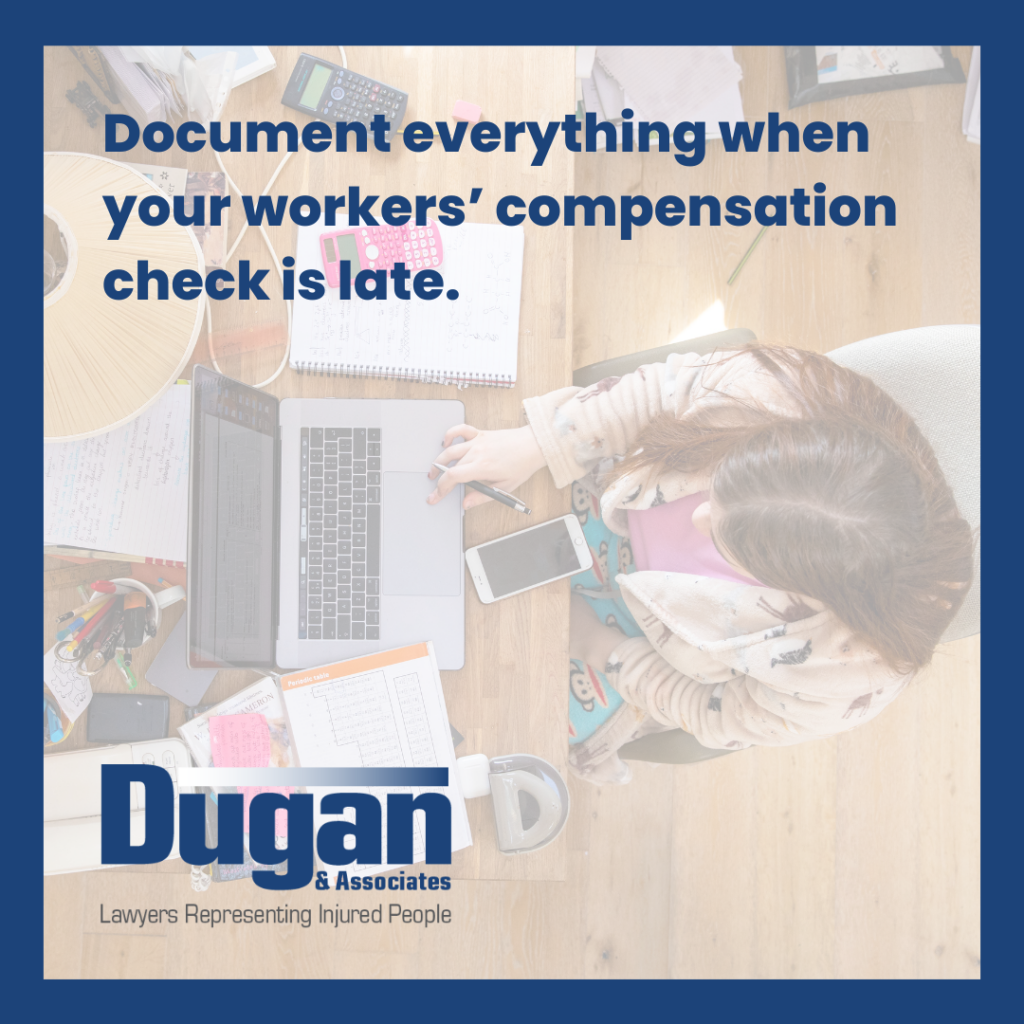 Document everything when your workers' compensation check is late. Image shot from overhead of a woman in her home at a desk with mobile phone, laptop, and papers on it.